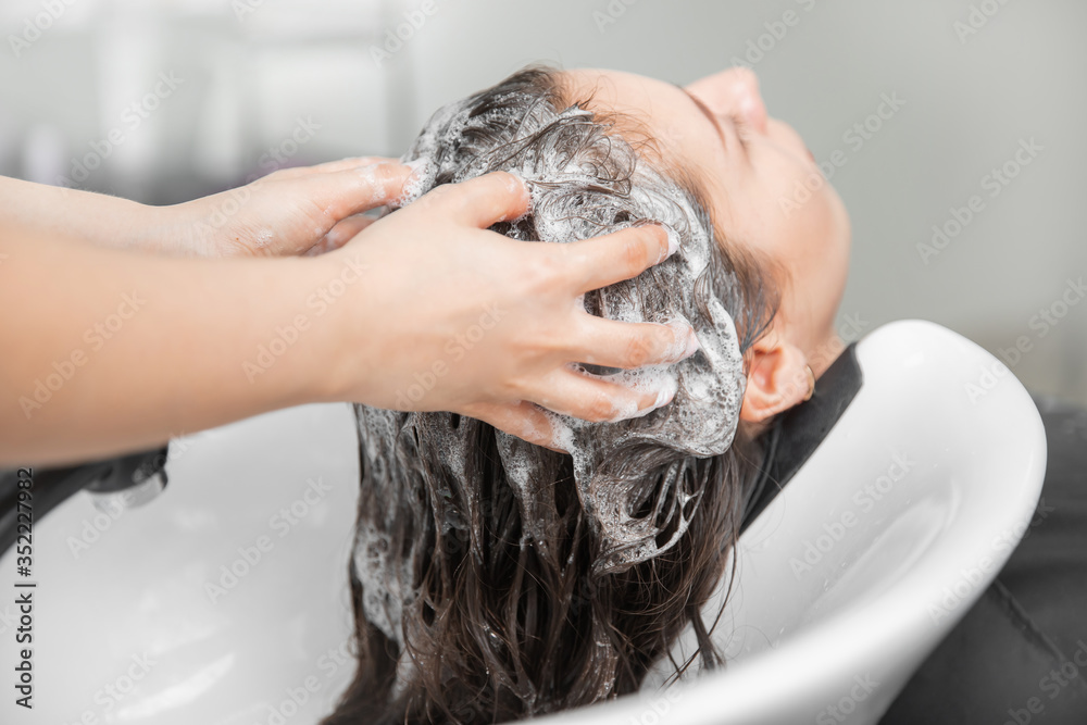 © Parilov - Beautiful brunette woman getting hair wash in beauty salon