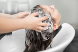 Beautiful brunette woman getting hair wash in beauty salon