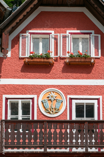 View of the facade of a traditional house featuring the pictorial relief of Alpine flowers gentian and edelweiss - Hallstatt, Salzkammergut, Austria