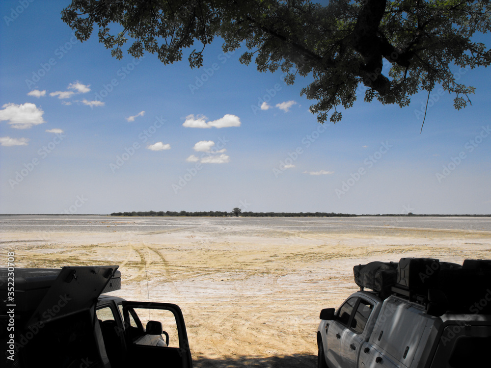 Two discovery vehicles looking over the Nxai Pan in Botswana during December summer month