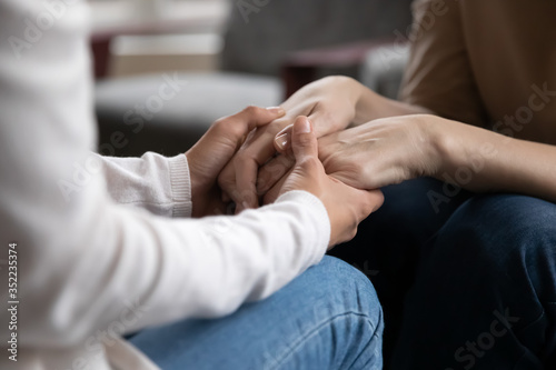 Close up crop of loving grownup girl and mature mom talk speak have tender close intimate conversation at home, caring senior mother and adult daughter hold hands, show support and understanding photo