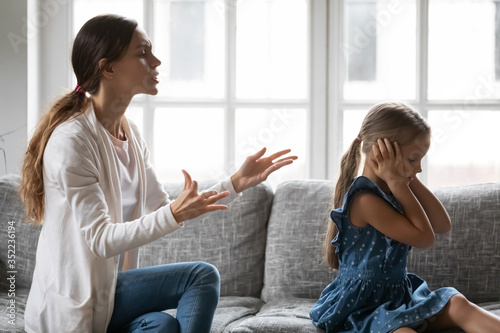 Εκτύπωση καμβά Stubborn small preschooler girl child close ears ignore loud young mother lectur