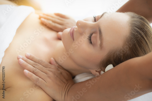 Young woman get massage in spa salon at luxury spa room. Customer receiving shoulders massage on spa bed that make her relieve stressed Oriental massage therapist massage customer body. She get relax