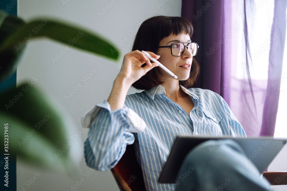 Woman using digital tablet with blank screen on sofa at home. The girl chatting with friends in social network, shopping online, writing email. Technology, freelance and work concept. Woman using digital tablet with blank screen on sofa at home. The girl chatting with friends in social network, shopping online, writing email. Technology, freelance and work concept.