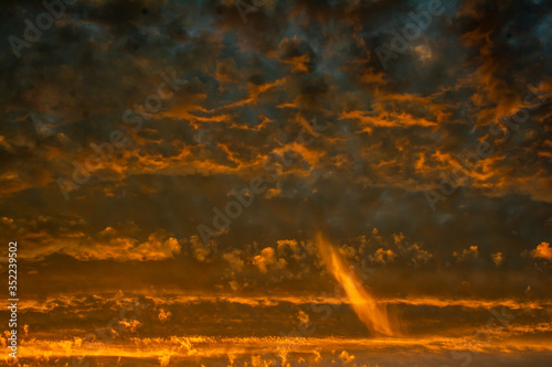 The sky is completely covered by golden yellow clouds illuminated by the sun. Sunset or dawn.