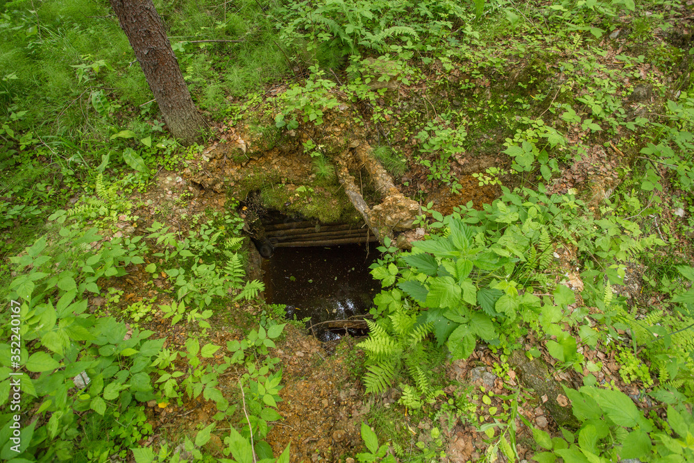 Old abandoned emerald gems mine open pit in forest with wooden timbering Old abandoned emerald gems mine open pit in forest with wooden timbering