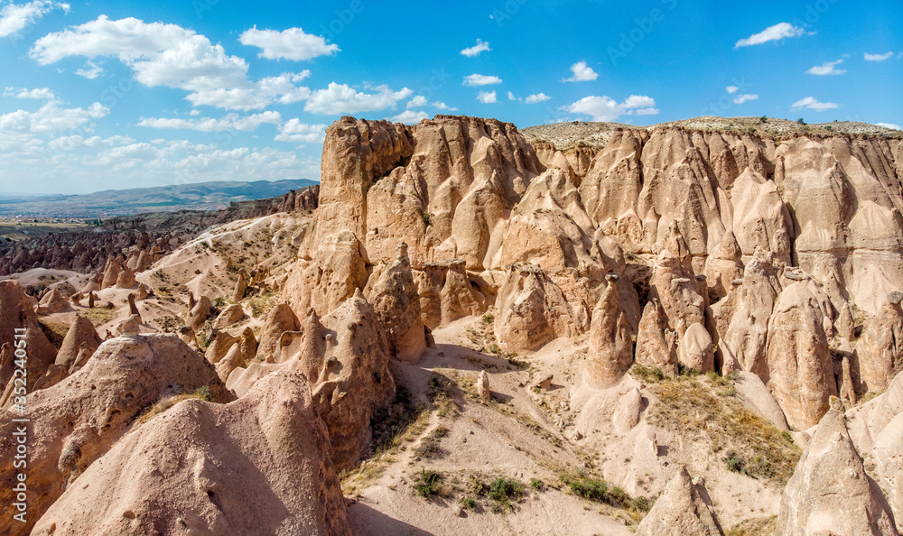 Obraz premium Aerial view of Goreme National Park, Tarihi Milli Parki, Turkey. The typical rock formations of Cappadocia with fairy chimneys and desert landscape. Travel destinations, holidays and adventure