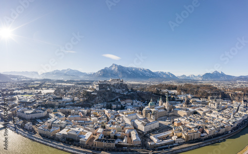 Aerial drone view of snowy Hohensalzburg fortress with view of Unesberg mountain in winter morning