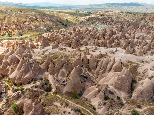 Aerial view of Goreme National Park, Tarihi Milli Parki, Turkey. The typical rock formations of Cappadocia with fairy chimneys and desert landscape. Travel destinations, holidays and adventure
