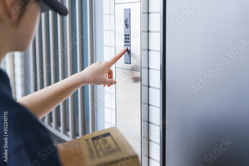 delivery person and door bell with intercom and camera photo