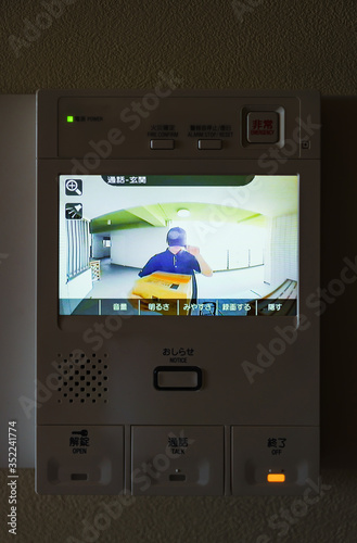 delivery person and door bell with intercom and camera photo