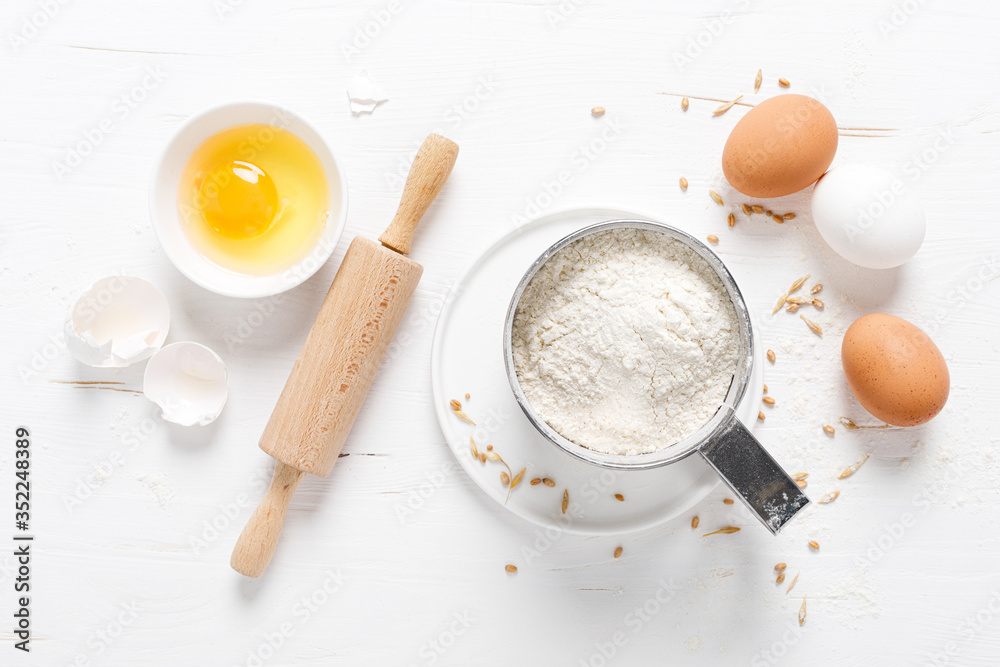 Flour and eggs on white kitchen worktop, baking culinary background, copy space, overhead view Flour and eggs on white kitchen worktop, baking culinary background, copy space, overhead view