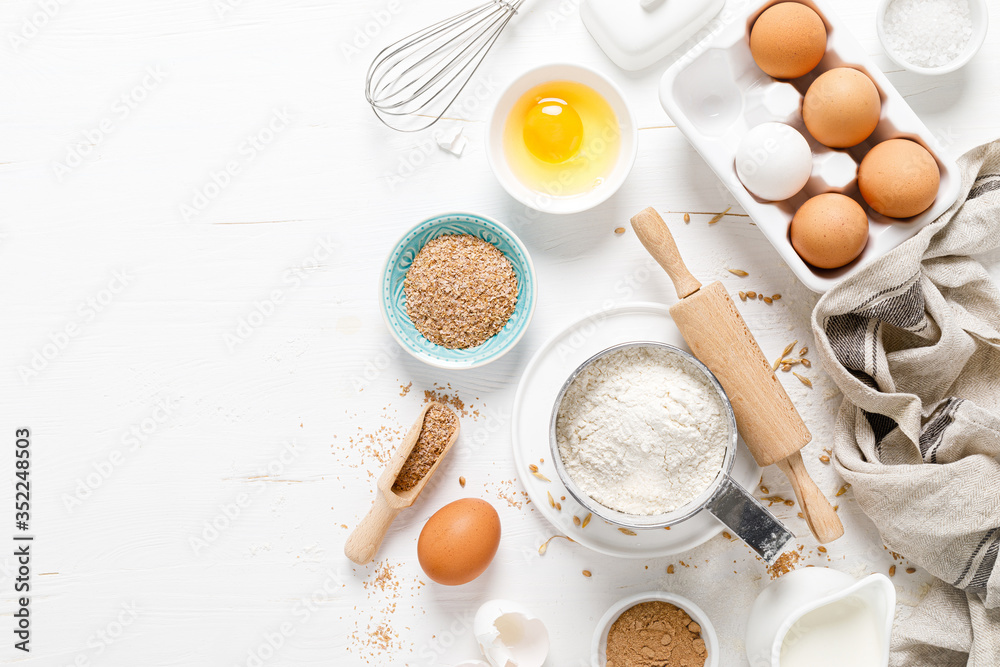 Baking homemade bread on white kitchen worktop with ingredients for cooking, culinary background, copy space, overhead view Baking homemade bread on white kitchen worktop with ingredients for cooking, culinary background, copy space, overhead view