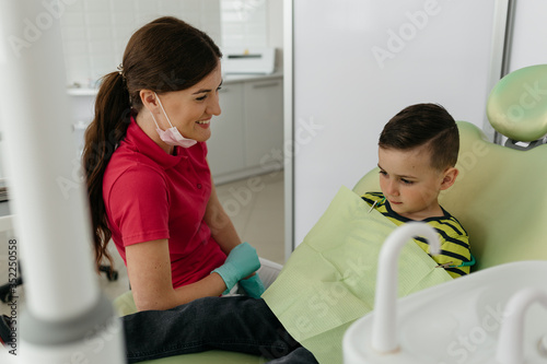 Dentist and nurse are curing a little boy patient.