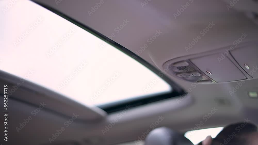 The girl presses the button to close the hatch in the car and the hatch closes. Close up, no face The girl presses the button to close the hatch in the car and the hatch closes. Close up, no face