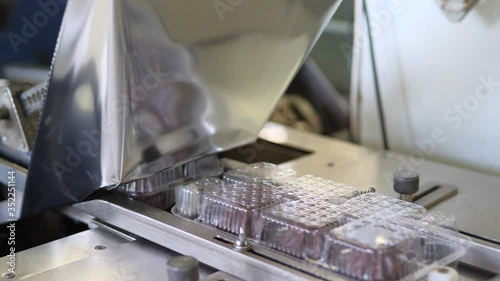Plastic wrapping machine on production line packs food during coronavirus