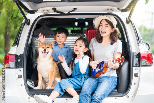 Happy asian children and Mother with shiba inu sitting and Sing Song in car.