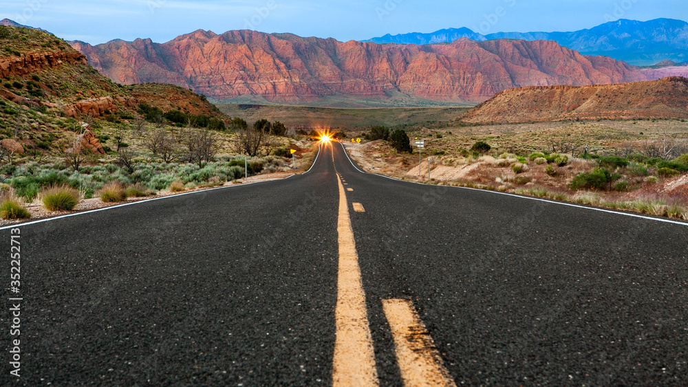 road in the desert of Utah shot low angle in the middle of the road with rocky red mountains as background road in the desert of Utah shot low angle in the middle of the road with rocky red mountains as background