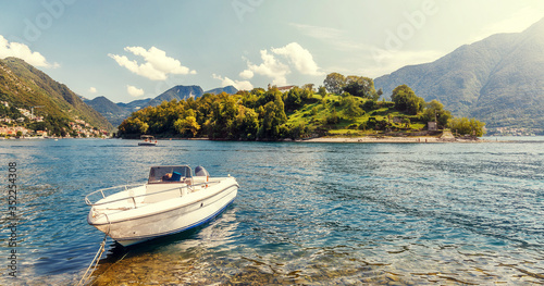 Sunny landscape of Como lake. summer view of Comacina island and luxury boat from the hiil of Ossuccio village, Province of Como, region Lombardy, Italy, Europe. popular Italyan resort. photo