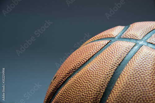 orange basketball ball close-up gray background, part of a basketball