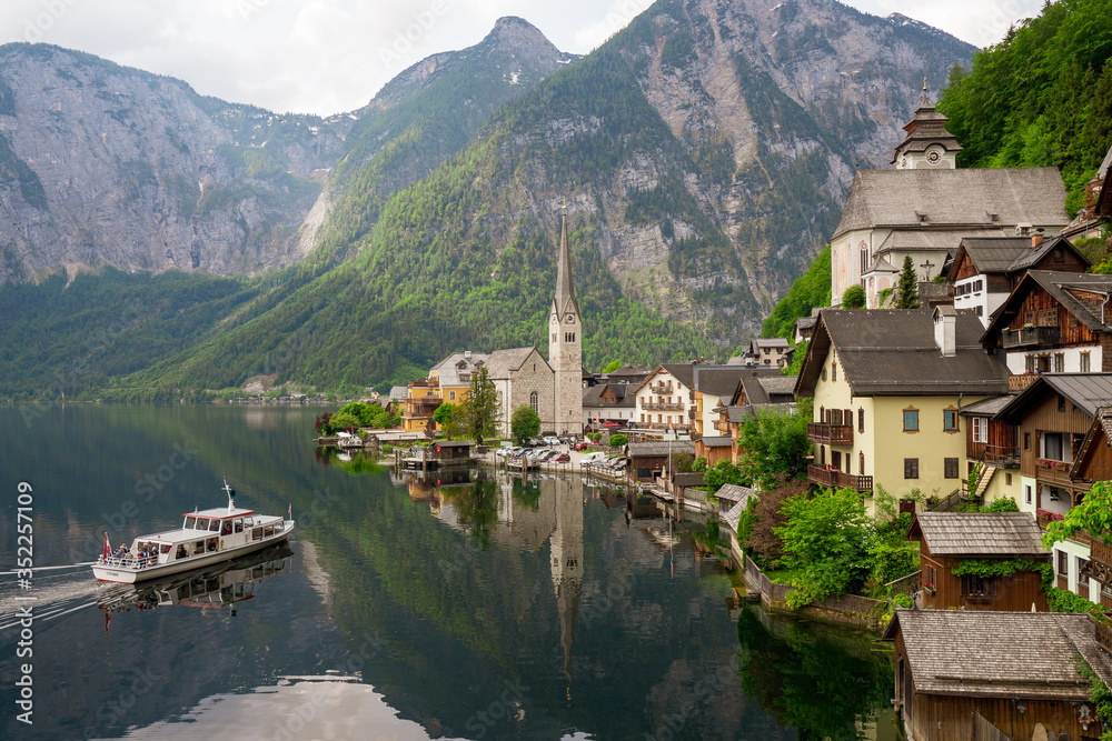 Scenic view of the famous mountain village Hallstatt in the Salzkammergut region, OÖ, Austria, with the ferry approaching the pier