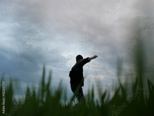 Man walking in a Meadow. Green field in the summer on morning day  Young man walking in the field  alone.