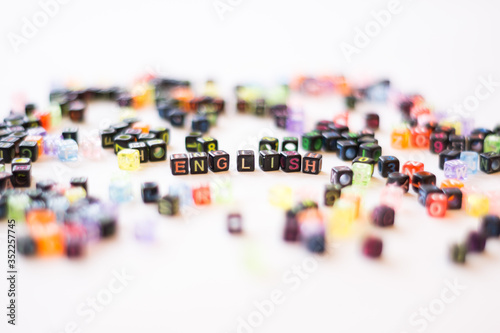 Colorful alphabets beads on white background, different colors with letters, concept image