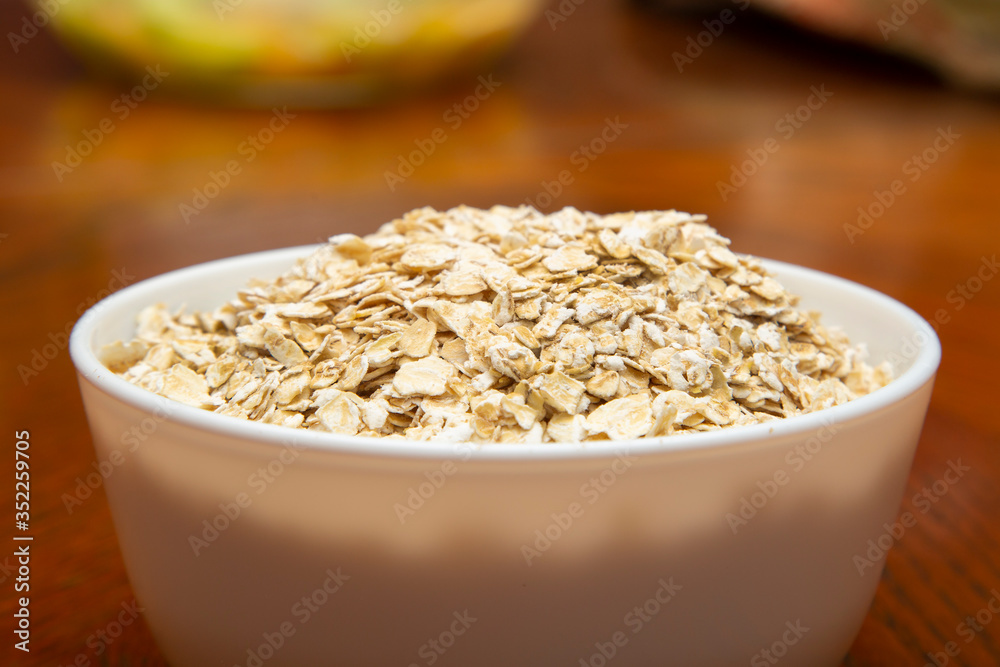 Oatmeal in a white Cup on a brown table. Oatmeal in a white Cup on a brown table.