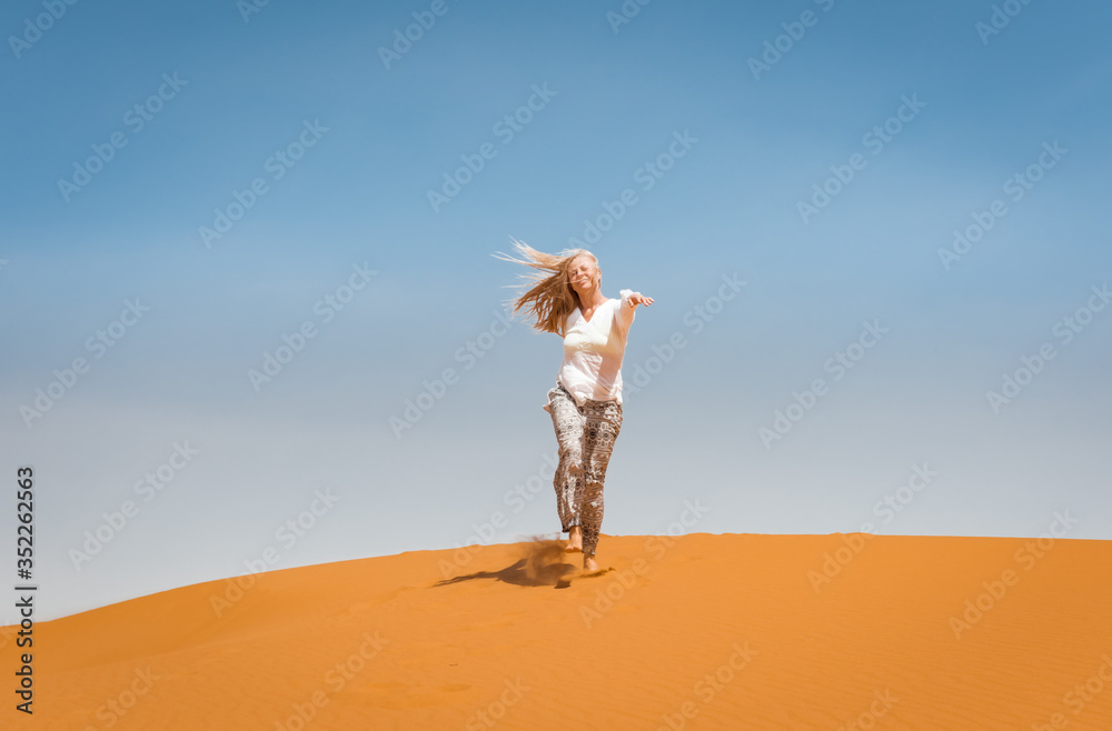 Sporty woman in Merzouga dunes of Sahara desert Morocco Africa. Travel and inspiration concept Sporty woman in Merzouga dunes of Sahara desert Morocco Africa. Travel and inspiration concept