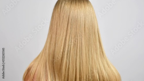 Haircare. Beautiful healthy straight hair. Woman moves blonde long hair.