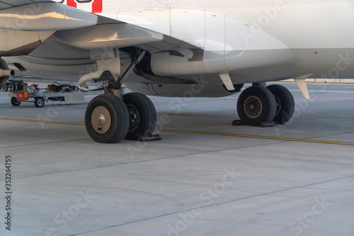 Airplane wheels standing at terminal for discharge on grey ground with copy space. 