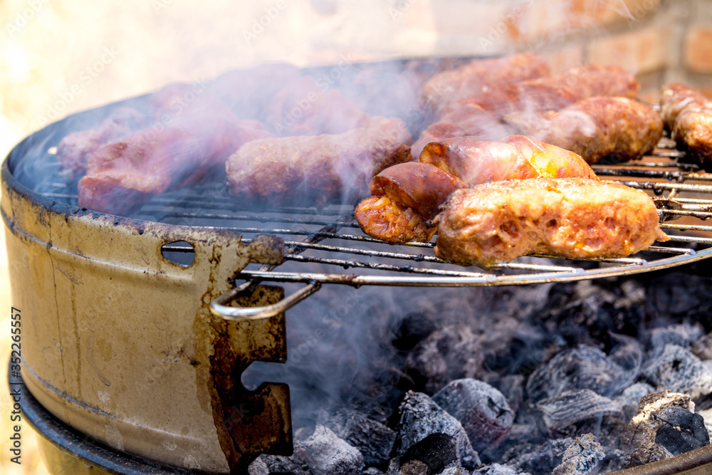 Sausages and frankfurters being cooked on the fire. Family barbecue. Sausages and frankfurters being cooked on the fire. Family barbecue.