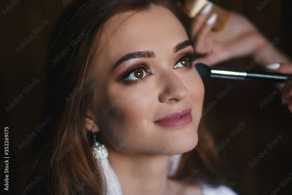 
young attractive girl with beautiful eyes do makeup in a beauty salon