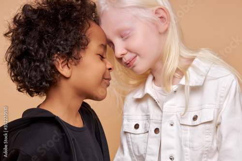 diverse black and albino kids in love, they have tender feeling for each other, people with unusual hair and skin color photo