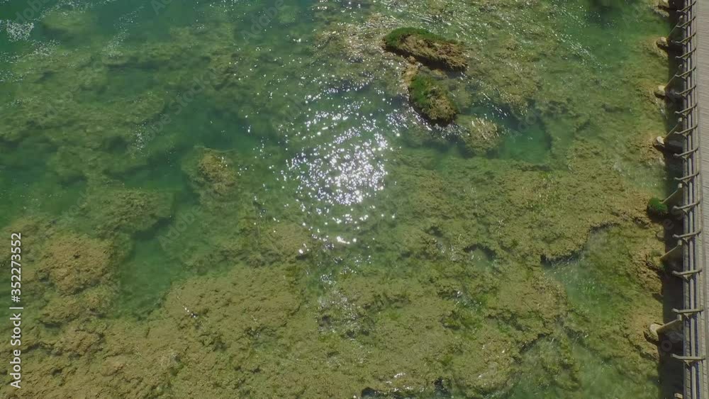 Aerial tilt up shot of waterfall in Krka river on sunny day, drone is moving forward over water Aerial tilt up shot of waterfall in Krka river on sunny day, drone is moving forward over water