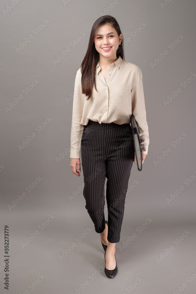 Portrait of beautiful business woman smiling on gray background Portrait of beautiful business woman smiling on gray background