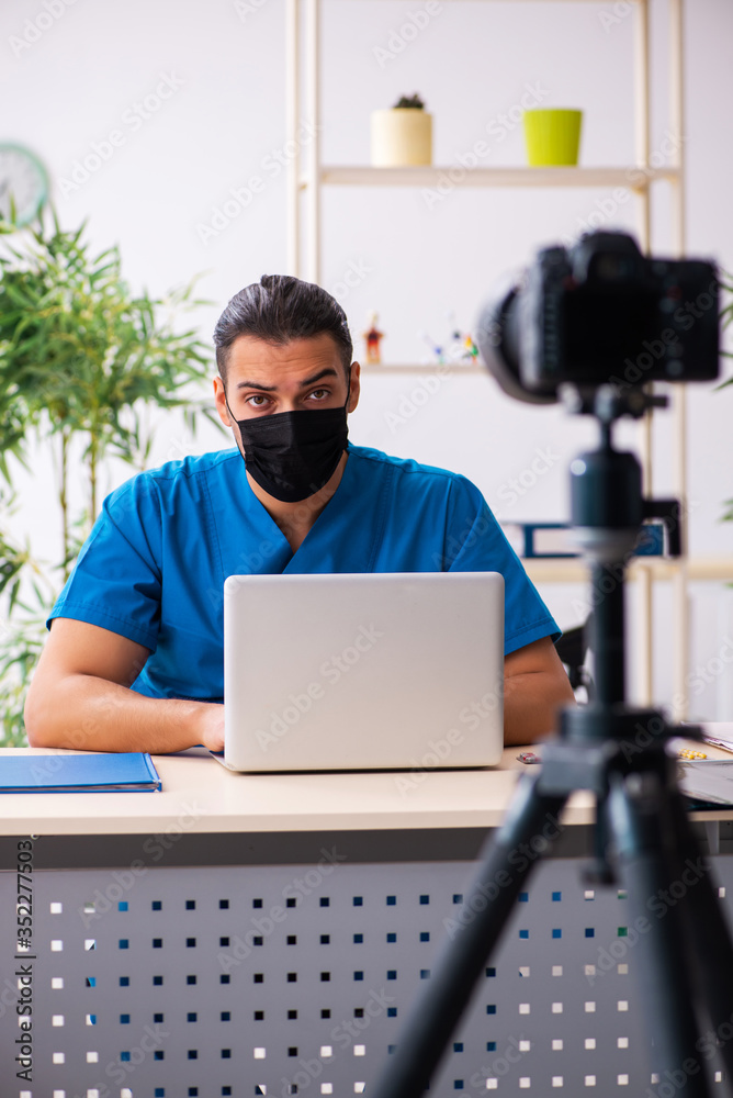 Young male doctor recording video for his blog