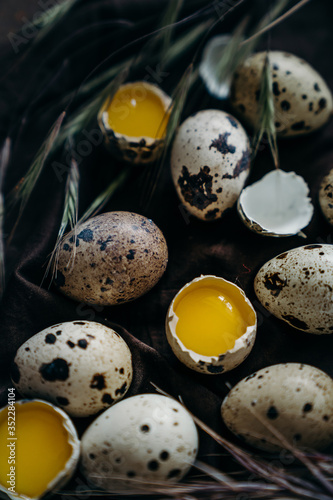 Quail eggs in craft paper box on dark wooden background, Part of the eggs is broken, visible yolk. farm products, organic products, Healthy food concept