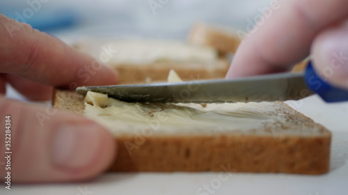 Morning Breakfast with Butter on the Toast, Spreading Margarine on a Fresh Slice of Bread in the Kitchen