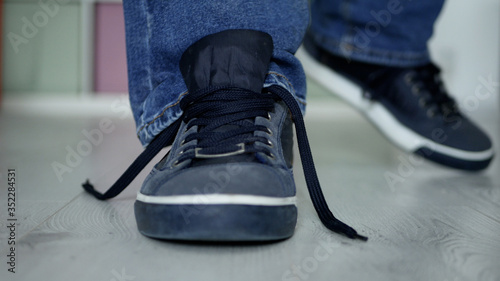 Man Preparing for a Walk with Laces Untied on His Sports Shoes
