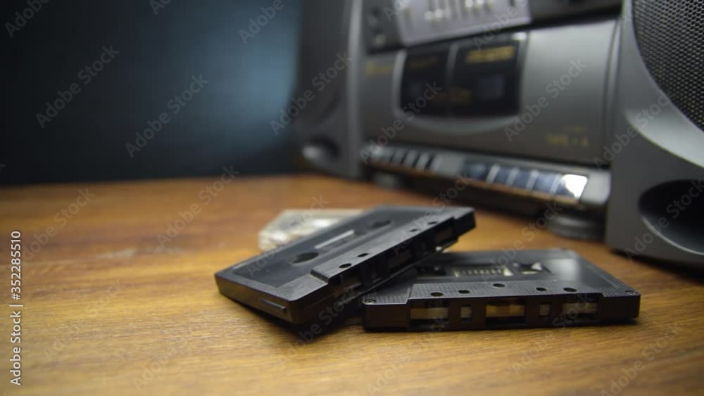 Old audio cassettes and a player on a wooden table Old audio cassettes and a player on a wooden table