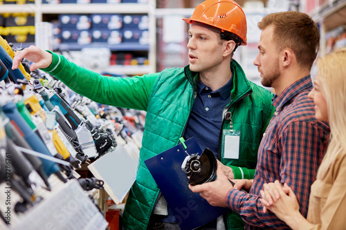 affable open-minded warehouse worker offers the best commodity for customer. handsome man want new equipment, make purchase