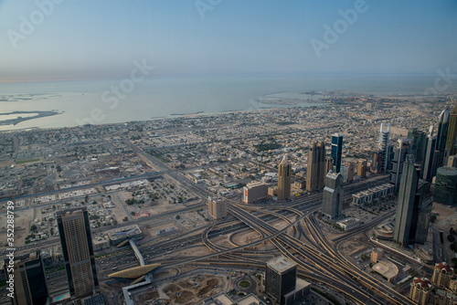 view of Dubai from above from the observation deck of the Burj Khalifa skyscraper on Sheikh Zayed Highway, Persian Gulf in the daytime at sunset