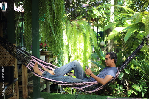 Man sitting in garden with green plants