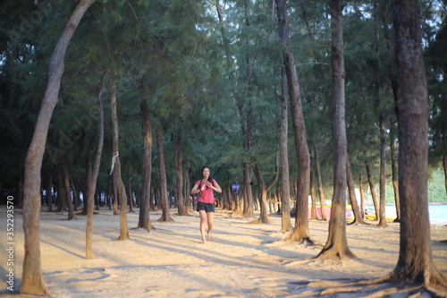 A woman standing on a pine forest by the beach