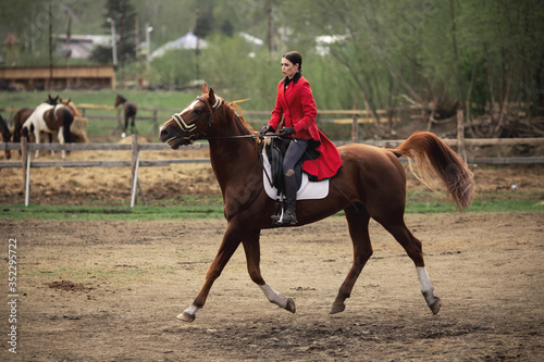 Woman jockey is riding brown horse, Equestrian sport outdoors