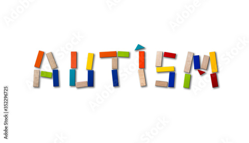 Concept of autism. Wooden word on colored background