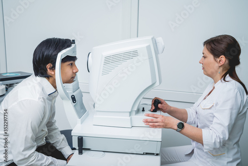 Consultation with an ophthalmologist. Young asian man and woman doctor 