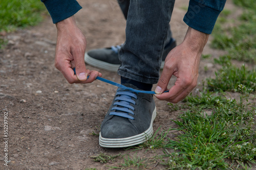 man tie sport shoelaces in nature