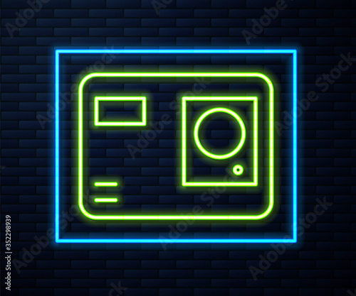 Glowing neon line Action extreme camera icon isolated on brick wall background. Video camera equipment for filming extreme sports. Vector